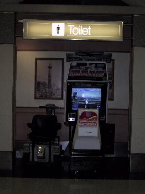 A flight sim game at the waiting area for the gate at an airport.